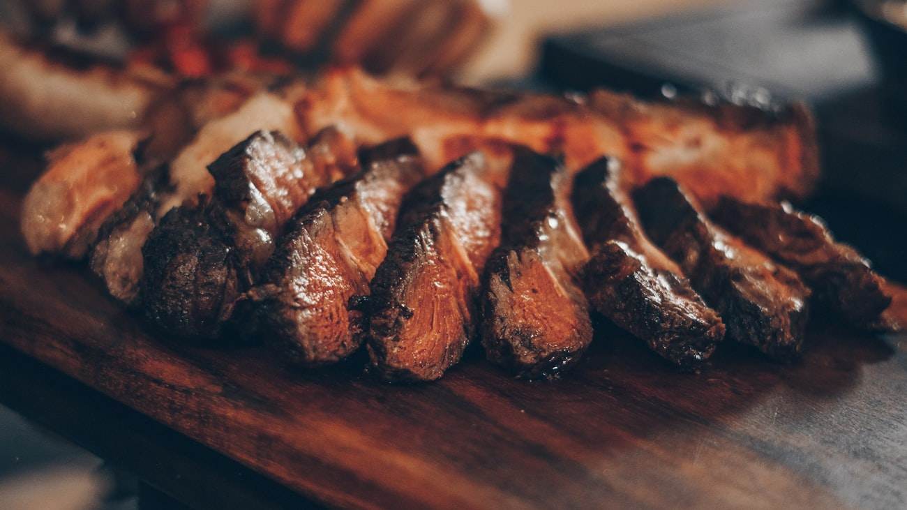 Entrecôte saisie sur la braise, tranchée sur planche